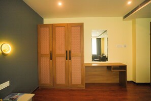 Una habitación con un armario de madera, un escritorio y un espejo.