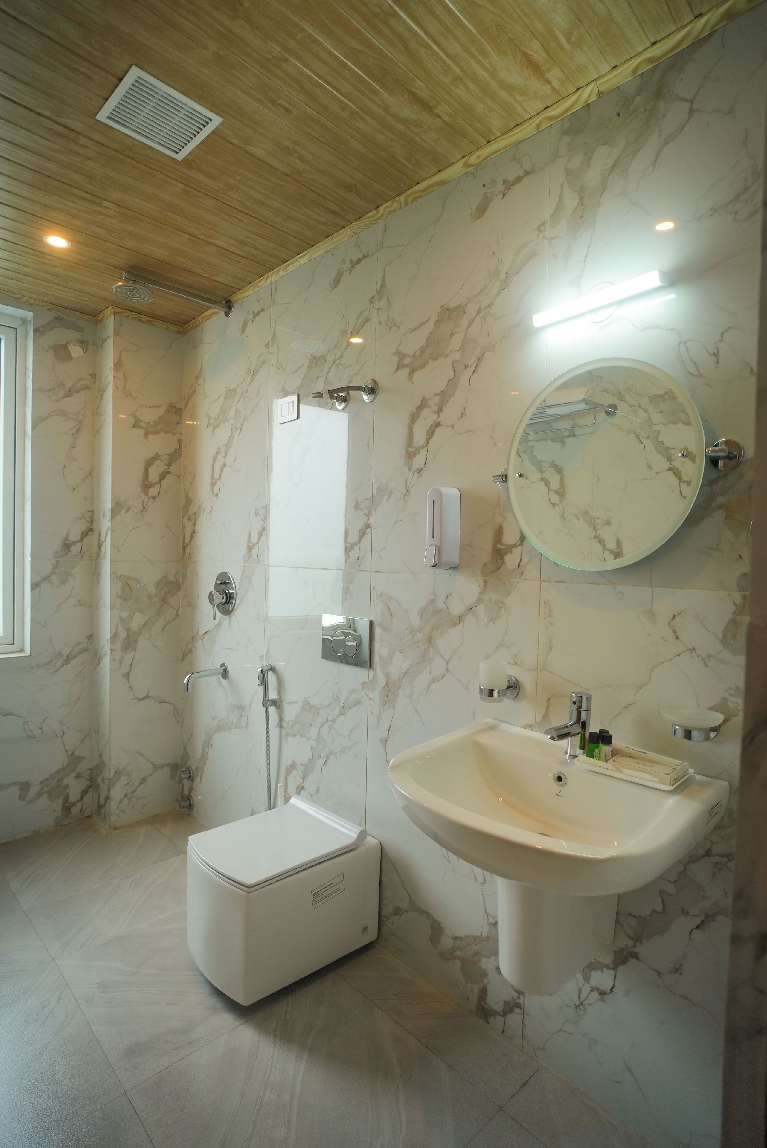 A bathroom with a shower, a toilet, a sink, and a mirror.