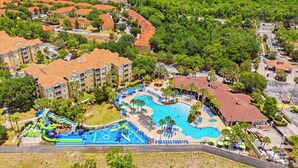 Ett flygbildsfoto av ett semesterområde med en stor pool, en vattenpark och flera byggnader med röda tak.