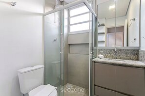A modern bathroom with a glass-enclosed shower, a toilet, and a vanity with a sink and mirror. - Modern Studio 110 m From Lagoa da Conceicao Bdr523 (Florianópolis)