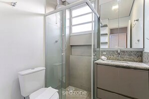 A modern bathroom with a glass-enclosed shower, a toilet, and a vanity with a sink and mirror. - Modern 110 m From Lagoa da Conceicao Bdr523 (Florianópolis)