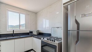 Una cucina moderna con piano cottura a gas, forno integrato, microonde e frigorifero in acciaio inossidabile.