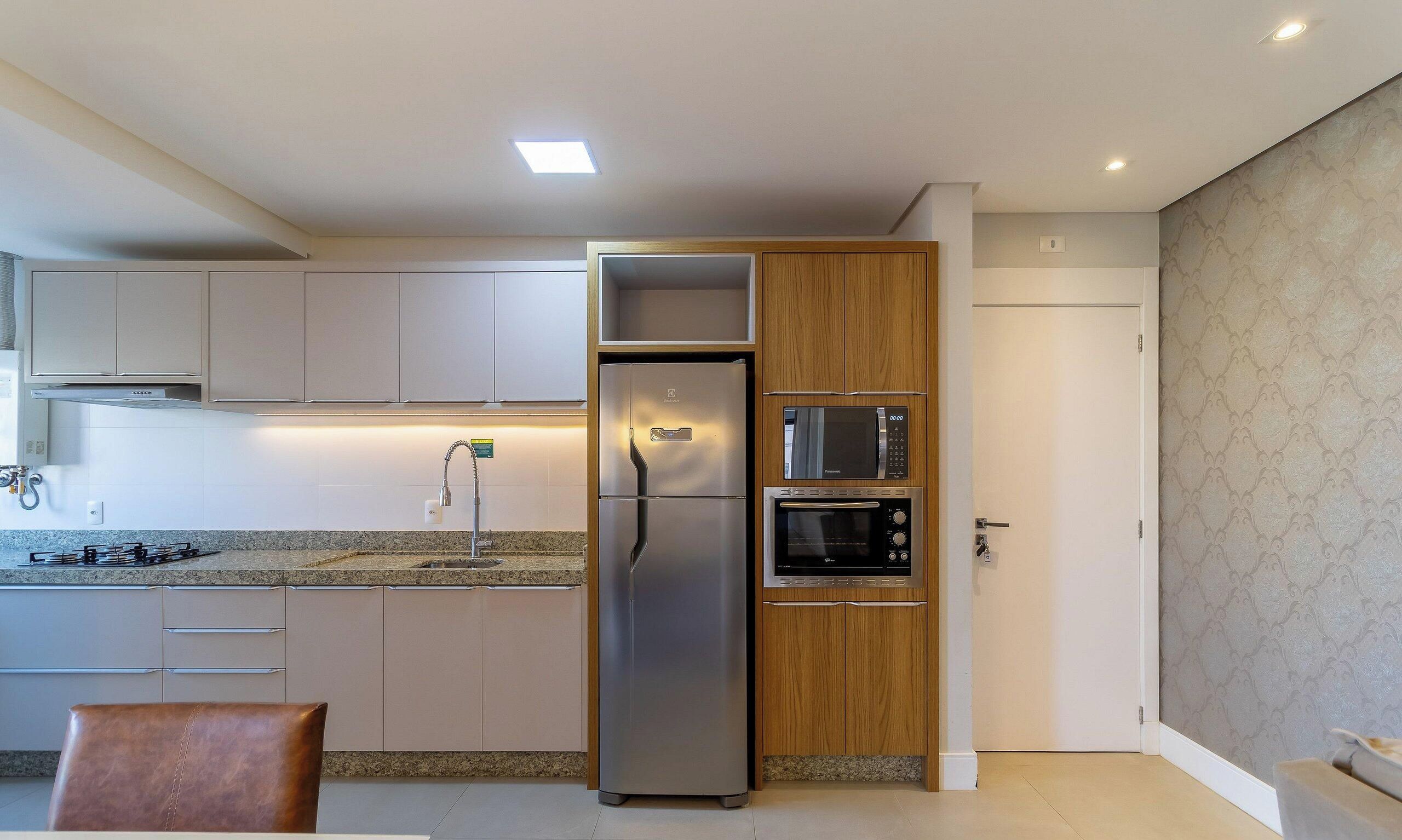 A modern kitchen with a built-in refrigerator, oven, and microwave.