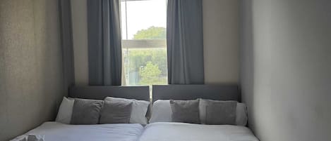 A double bed with two pillows and a folded towel on each side.