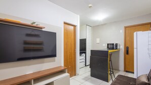 A compact kitchen with a microwave, refrigerator, and a small dining area. - 1BR Apart With Self Check-in, Asa Sul Gdp0010 (Brasília)