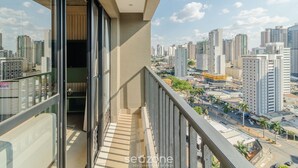 Un balcone con vista sulla città, una porta in vetro e una ringhiera.