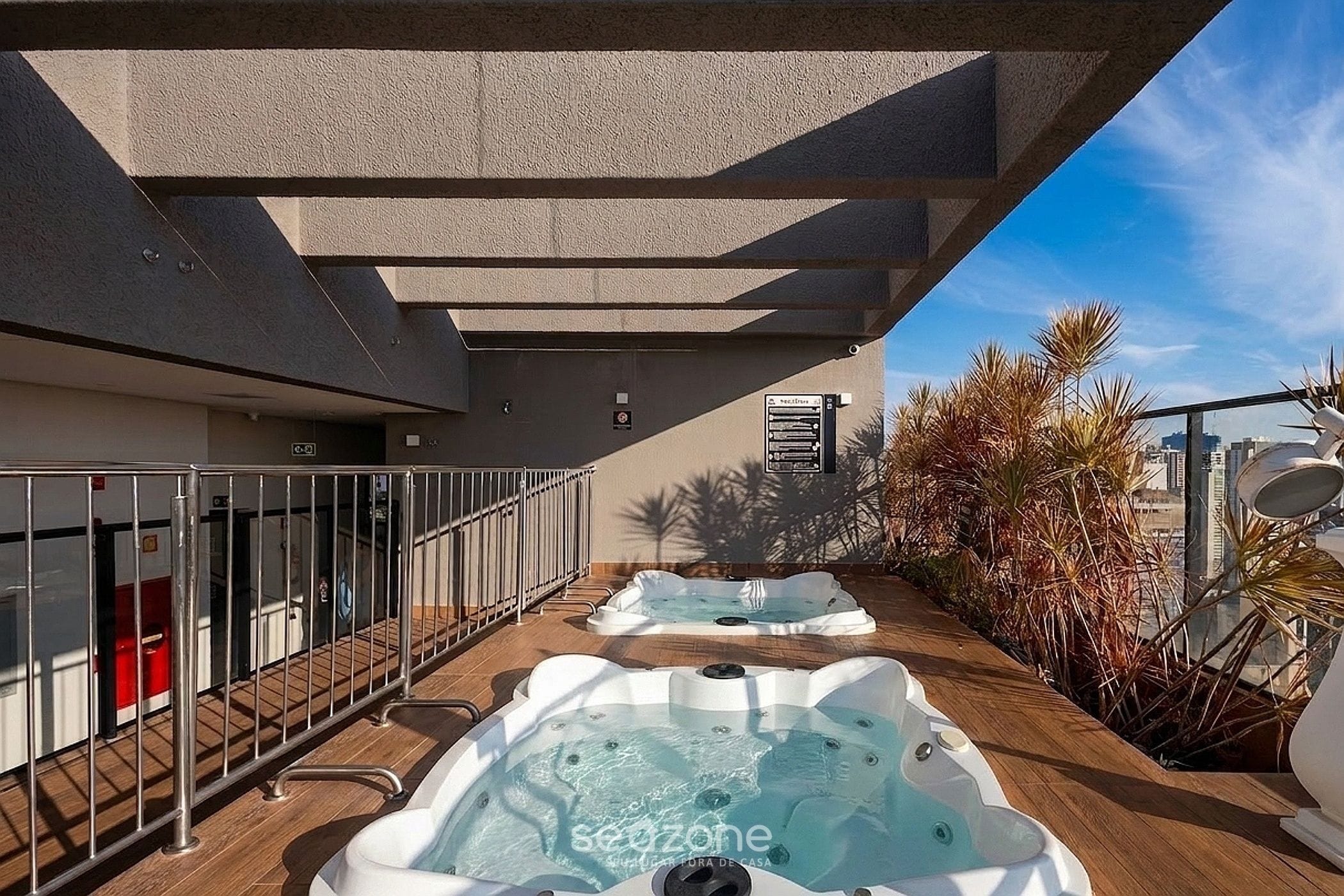 Terraza en la azotea con dos jacuzzis y vistas al horizonte urbano.