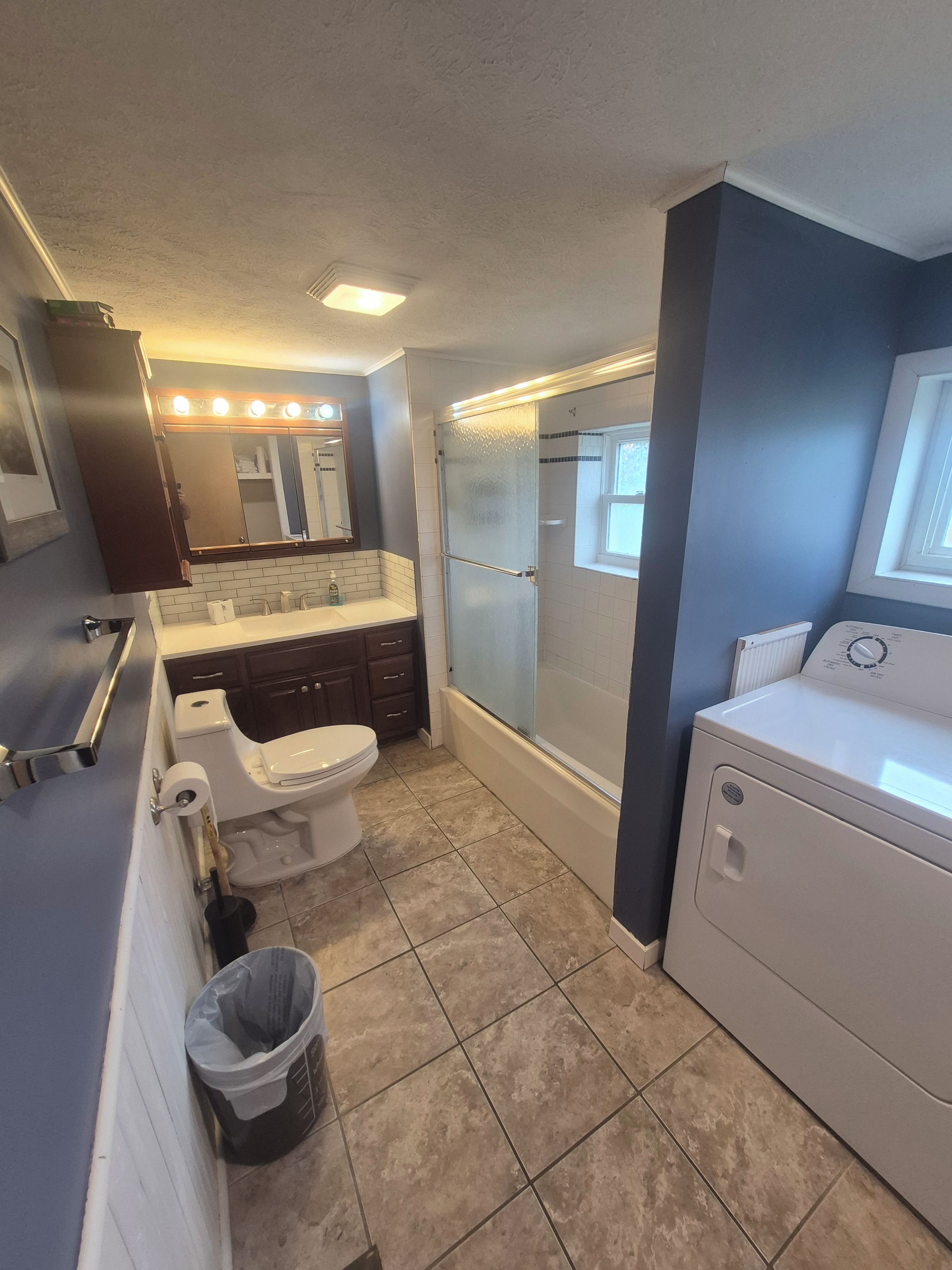 Une petite salle de bain comprenant des toilettes, un lavabo et une cabine de douche.