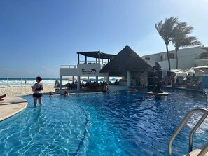 A swimming pool with a shaded area and a lifeguard stand. - Sunset Fishermens Beachfront Playa del Carmen (Playa del Carmen)