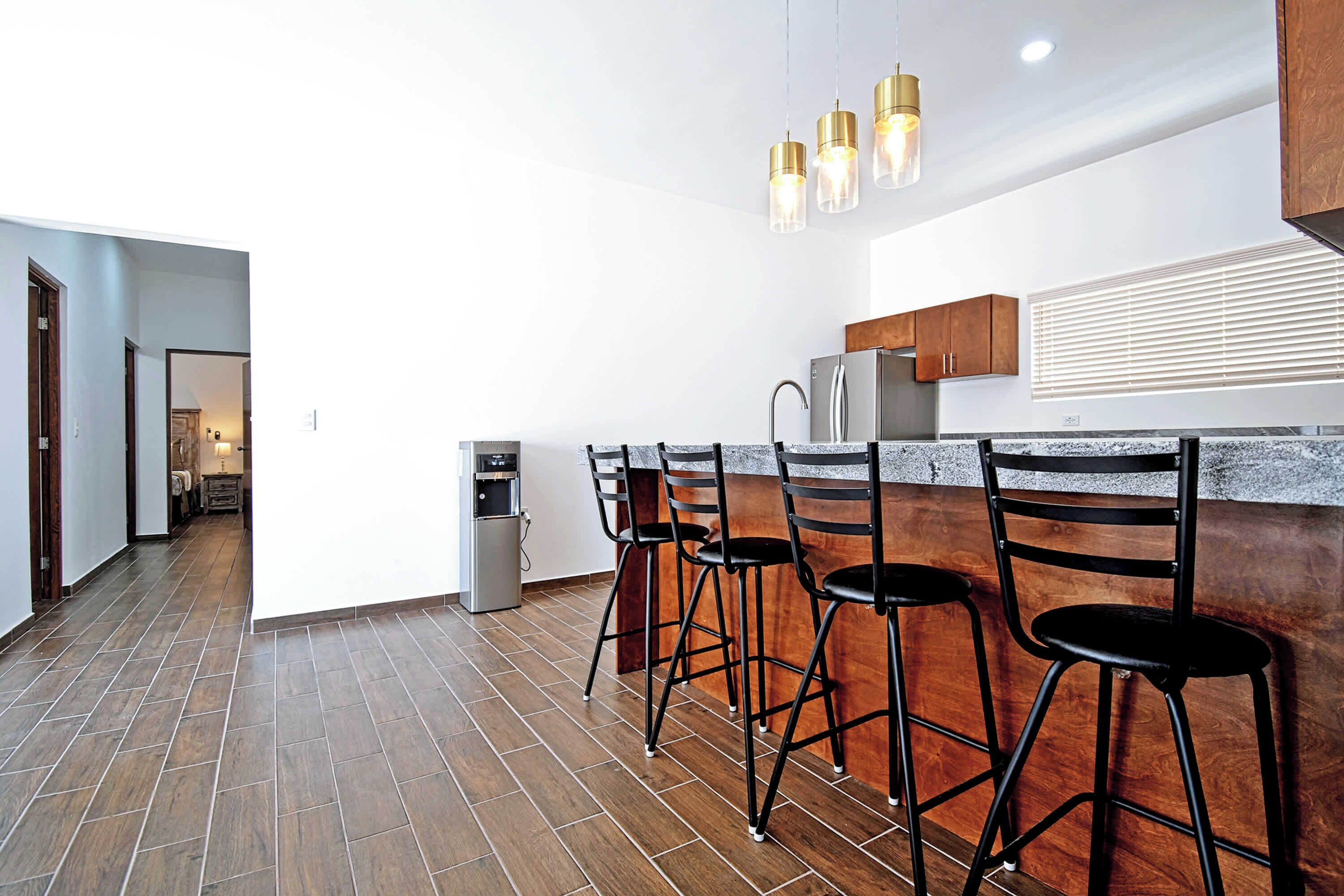 A modern kitchen with a bar area, stainless steel appliances, and a water dispenser.