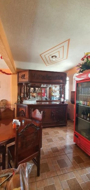 Zona de bar con mostrador de madera y refrigerador de Coca-Cola.