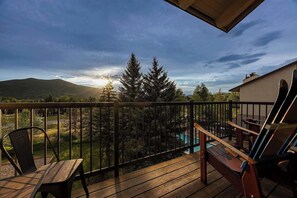 A wooden deck with a view of a mountain range and a pool. - Lofted Mountain Lookout (Steamboat Springs)