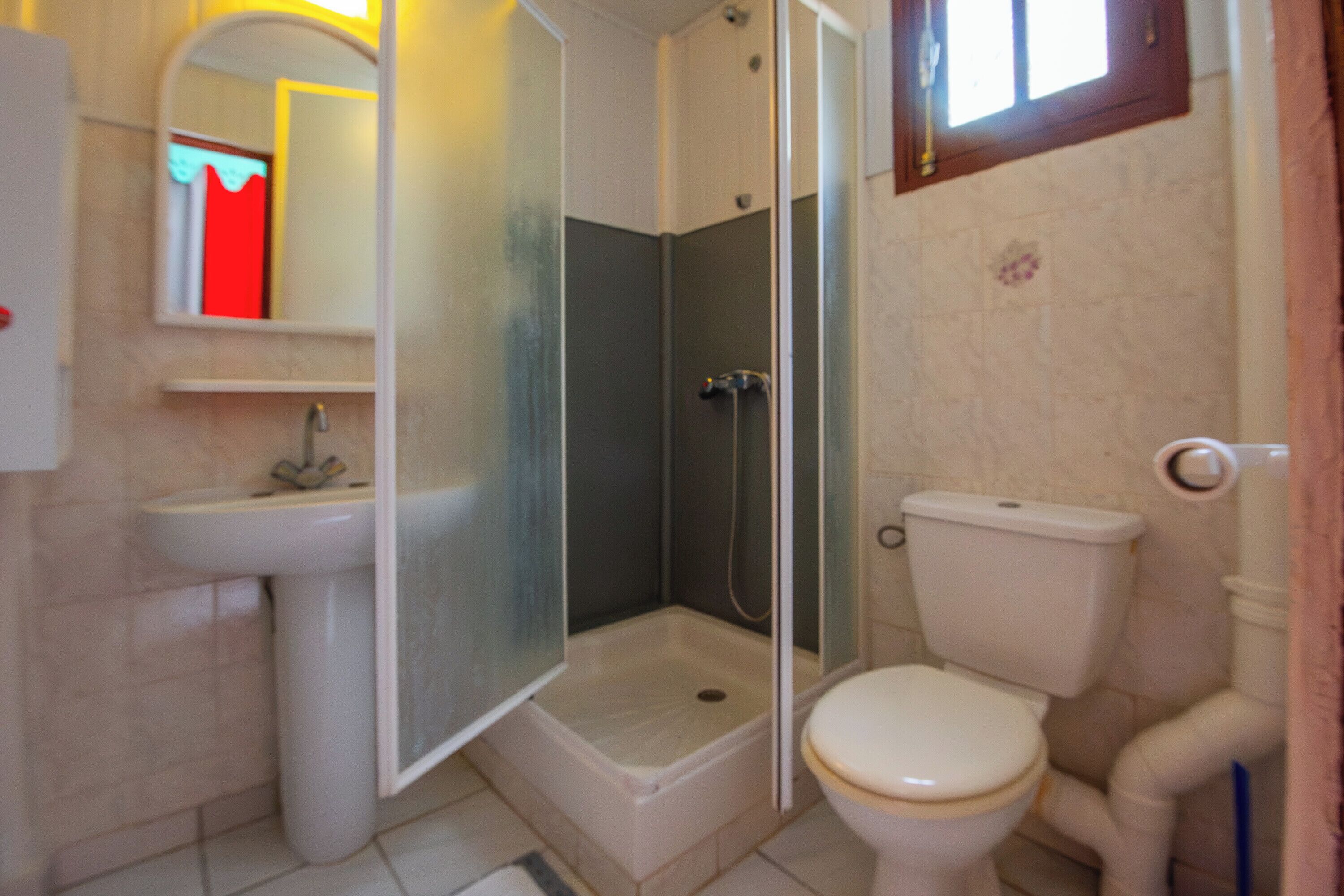 Ein Badezimmer mit Duschkabine, Toilette und Waschbecken.