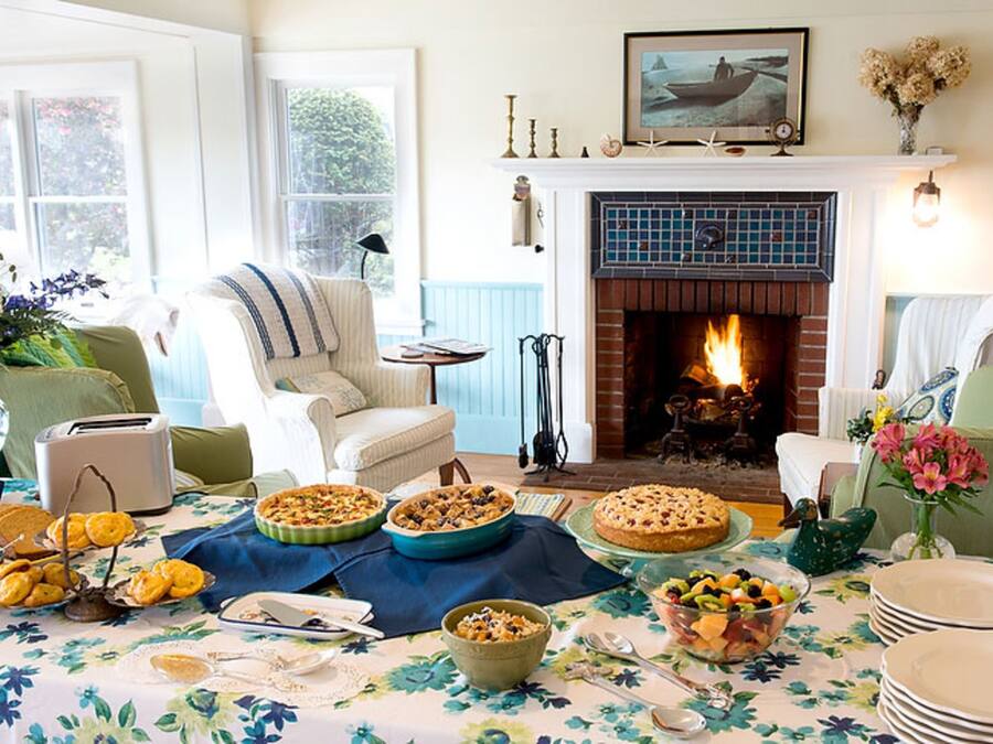 Una sala acogedora con chimenea, una mesa de comedor dispuesta con comida y un mobiliario cómodo.
