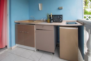 A compact kitchenette with a sink, microwave, and a small refrigerator. - Rêve Bleu 6 - Clim - Proche plage (LE DIAMANT)