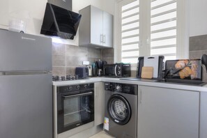 Ett modernt kök med inbyggd ugn, mikrovågsugn och diskmaskin.