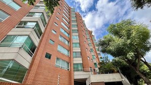 A high-rise building with a brick facade and multiple windows. - Vistas Increibles y Confort en El Rosal (Caracas)