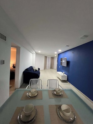 Ein modernes Hotelzimmer mit Essbereich, einem Bett und einem Badezimmer.