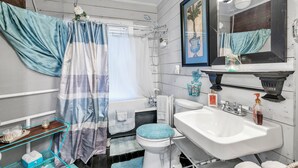 Un bagno con doccia, WC, lavandino e uno specchio illuminato.