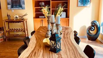 A dining area with a long wooden table, black chairs, and a central candle holder with candles.