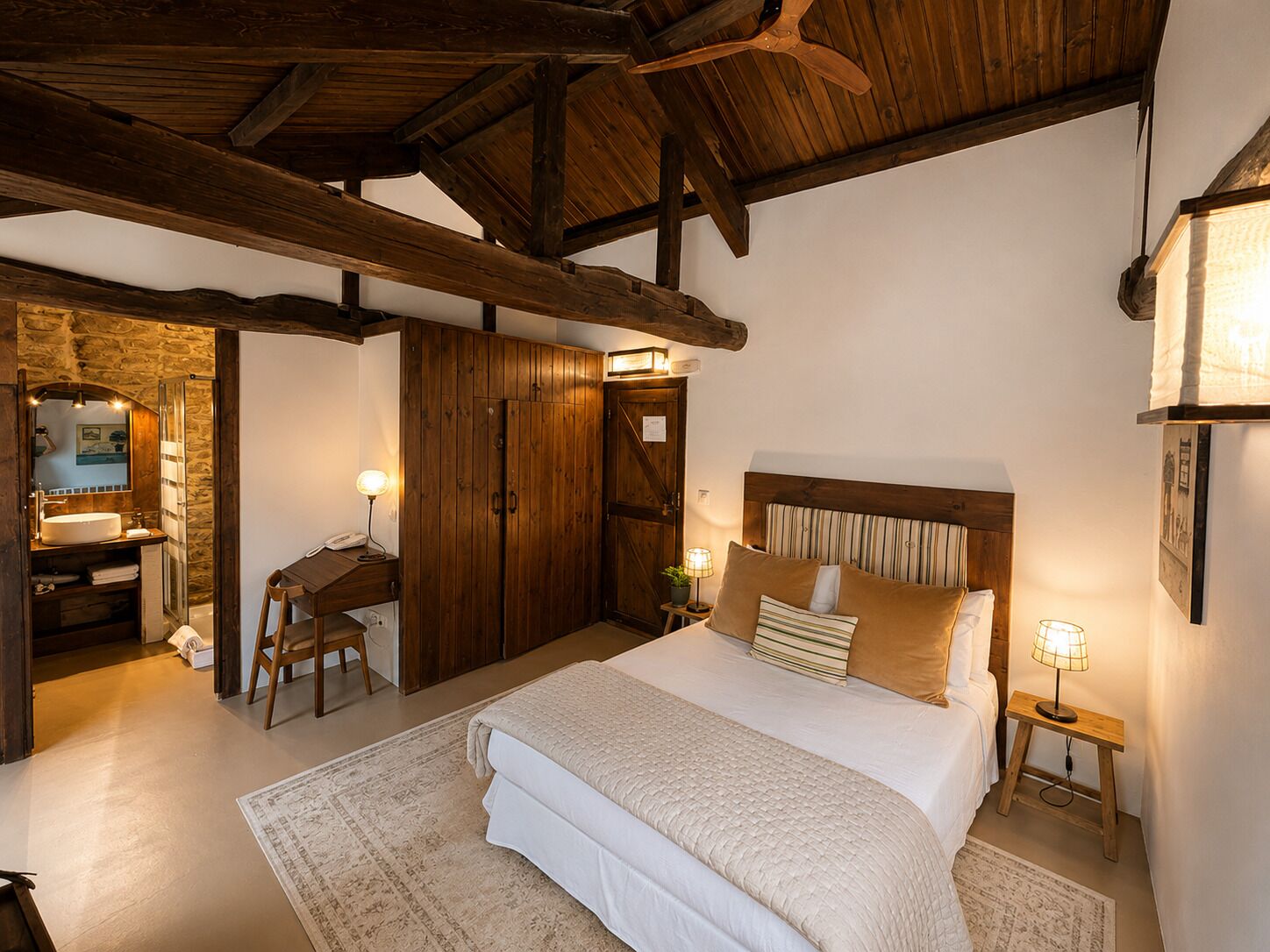 Un dormitorio con una cama grande, un armario de madera y un escritorio con una silla.