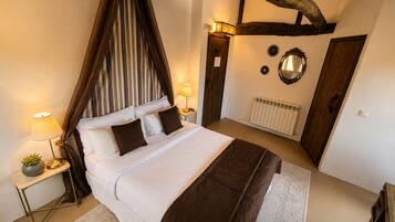 A bedroom with a four-poster bed, a bedside table with a lamp, a radiator, and a mirror on the wall.