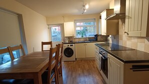 A compact kitchen with a washing machine, a sink, and a stove.