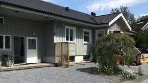 Ein Wohnhaus mit Kiesweg, Holzzaun und kleinem Garten.
