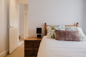 A bedroom with a bed, a nightstand, a lamp, and a door leading to another room. - Kempsey House -  Frampton on Severn, Gloucester, Tewkesbury (Frampton on Severn)