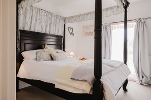 A four-poster bed with a dark headboard, white bedding, and a bedside table with a lamp and a glass of orange juice. - Kempsey House -  Frampton on Severn, Gloucester, Tewkesbury (Frampton on Severn)
