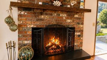 A fireplace with a brick wall, a mantel shelf, and a wooden floor.