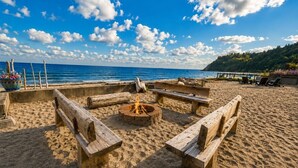 Una playa con bancos de madera y un hogar central.