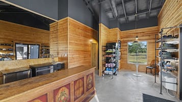 A wooden interior with a reception desk, a shoe display, and a view of the outdoors.