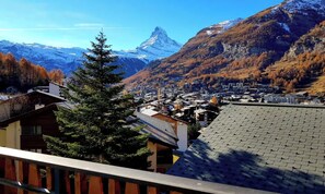 A residential area with houses, a prominent mountain peak, and a tree in the foreground. - SPECTACULAR VIEWS OF THE MATTERHORN, THIS WELCOMING ZERMATT APARTMENT (Zermatt)