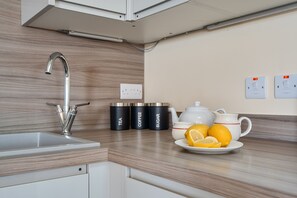 A modern kitchen with a stainless steel faucet, a sink, and a countertop with a plate of lemons and a teapot. - The Donkey Shed -  Sherborne, Dorchester, sleeps 6 guests  in 3 bedrooms (Sherborne)