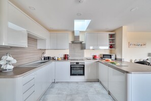 A modern kitchen with white cabinetry, a built-in oven, a microwave, and a coffee machine. - The Donkey Shed -  Sherborne, Dorchester, sleeps 6 guests  in 3 bedrooms (Sherborne)