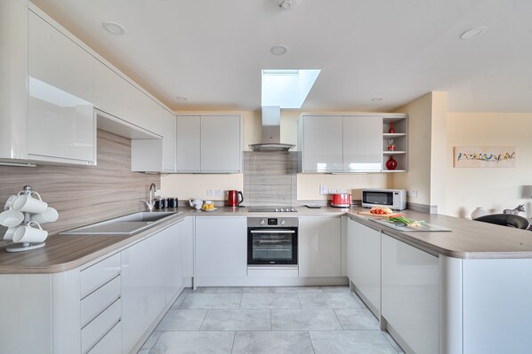 A modern kitchen with white cabinetry, a built-in oven, a microwave, and a coffee machine. - The Donkey Shed -  Sherborne, Dorchester, sleeps 6 guests  in 3 bedrooms (Sherborne)