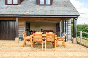 A wooden table and chairs set outside a building with a sloped roof and large windows. - The Donkey Shed -  Sherborne, Dorchester, sleeps 6 guests  in 3 bedrooms (Sherborne)