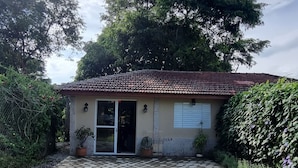 Ein kleines Haus mit Ziegeldach, einer Haustür und einer kleinen Veranda.