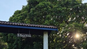 Ein überdachter Außenbereich mit einem Schild mit dem Schriftzug 'J. Bela Viera' und einem Zaun.