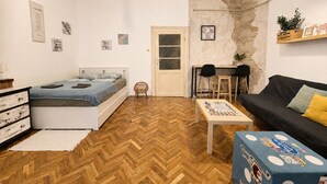 A compact living space with a bed, a sofa, a small table, and a chair. - Spacious 2bedroom apartment, 4 beds in the DOWNTOWN with FREE PARKING and AC (Budapest)