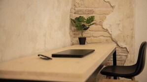 A minimalist workspace with a wooden table, a black chair, a tablet, and a potted plant. - Spacious 2bedroom apartment, 4 beds in the DOWNTOWN with FREE PARKING and AC (Budapest)