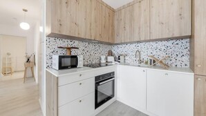 Una cocina moderna con armarios blancos, microondas, tostadora y horno.