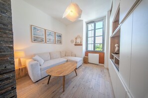 Ein modernes Wohnzimmer mit einer Couch, einem Holztisch und einem großen Fenster.