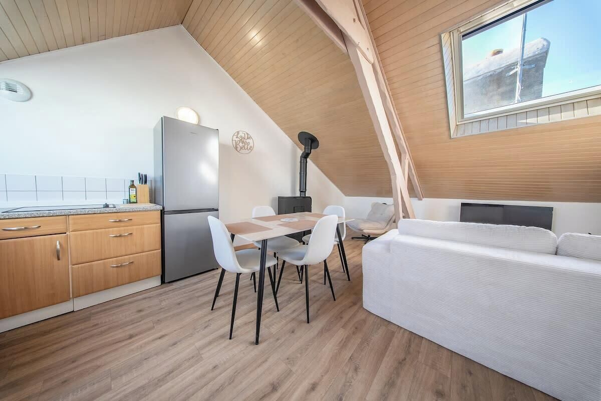 A compact kitchen with a dining area and a sofa.