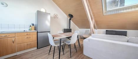 Una cocina compacta con comedor y sofá.