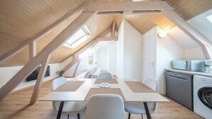 Un dormitorio estilo loft moderno con techo inclinado, un ventanal grande y un escritorio empotrado.