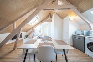 Ein modernes Schlafzimmer im Loft-Stil mit schrägverdeckter Decke, großem Fenster und integriertem Schreibtisch.
