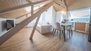 Un moderno loft con comedor, cocina y un gran ventanal.