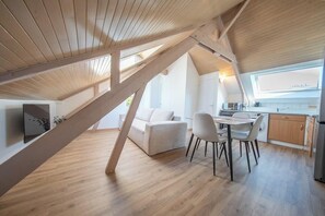 Ein stilvoller Loftraum mit Essbereich, Küche und großem Fenster.